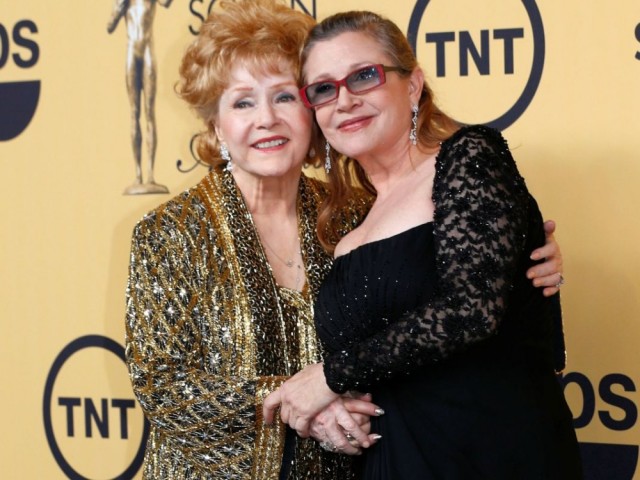 FILE PHOTO: Actress Debbie Reynolds poses with her daughter actress Carrie Fisher backstage after accepting her Lifetime Achievement award at the 21st annual Screen Actors Guild Awards in Los Angeles