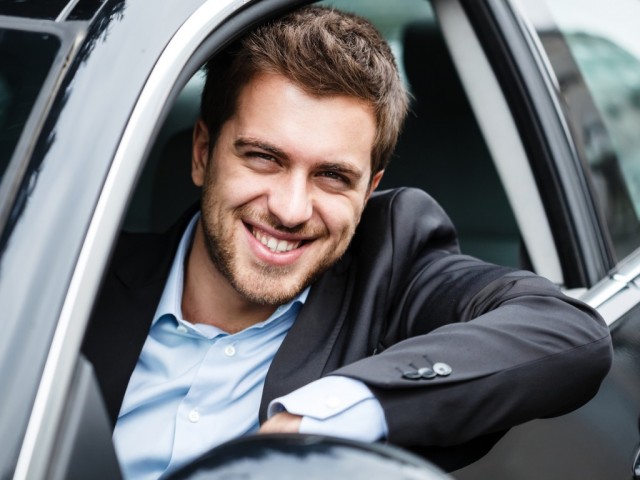 Portrait of an handsome guy driving his car