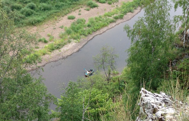 Рыбак сидя на берегу реки видит на гладкой поверхности воды изображение утреннего солнца