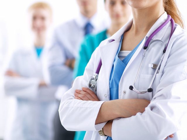 Attractive female doctor in front of medical group
