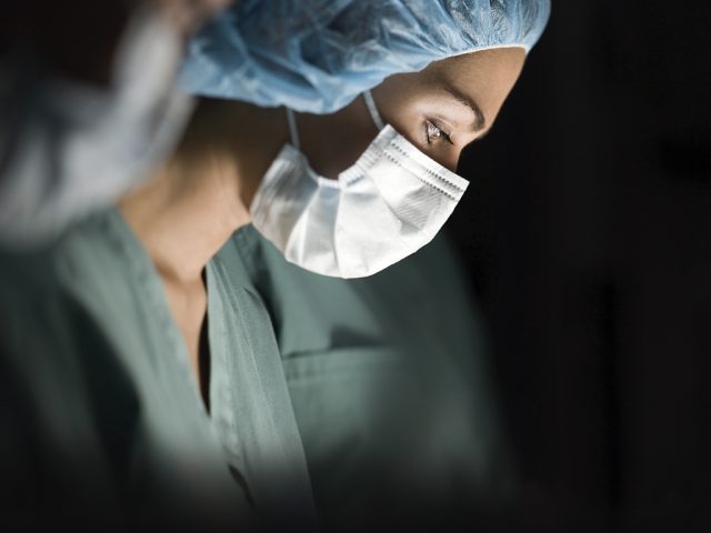 Profile of a female surgeon operating